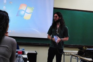 Daniel Dória falando sobre seu artigo "Psicoses ecoam por trás de uma barreira imaginária: o trauma geracional inglês pós-Segunda Guerra em The Wall (1982) e Tommy (1975)". Foto: Talita Moraes.